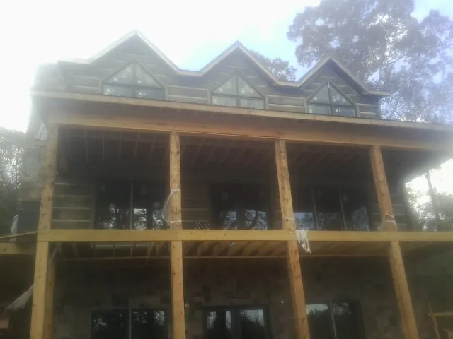 Dormers and porch framing on a large log home under construction — Roof Coating work by our crew in White Haven