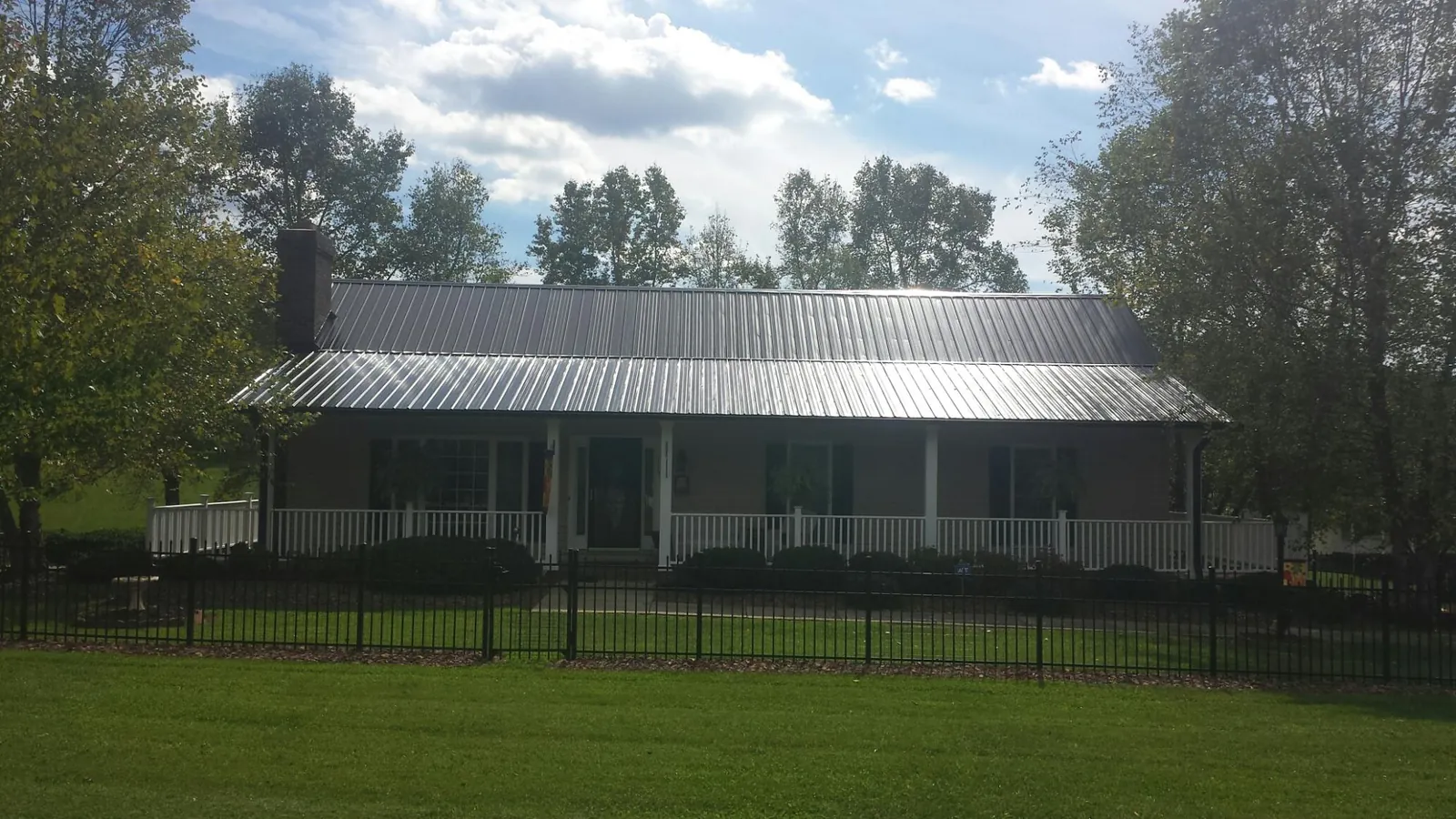 Gray metal roof on a brick ranch with a full width front porch — Gutter Guard Installation work by our crew in White Haven